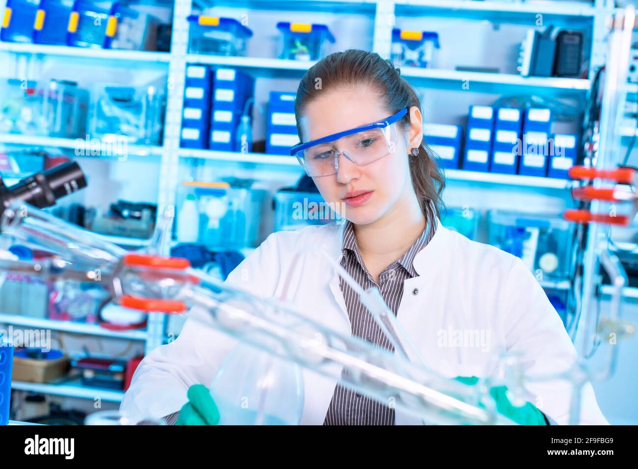 Giovane donna in un laboratorio farmacologico. Sviluppo e ricerca di farmaci antiallergici Foto Stock