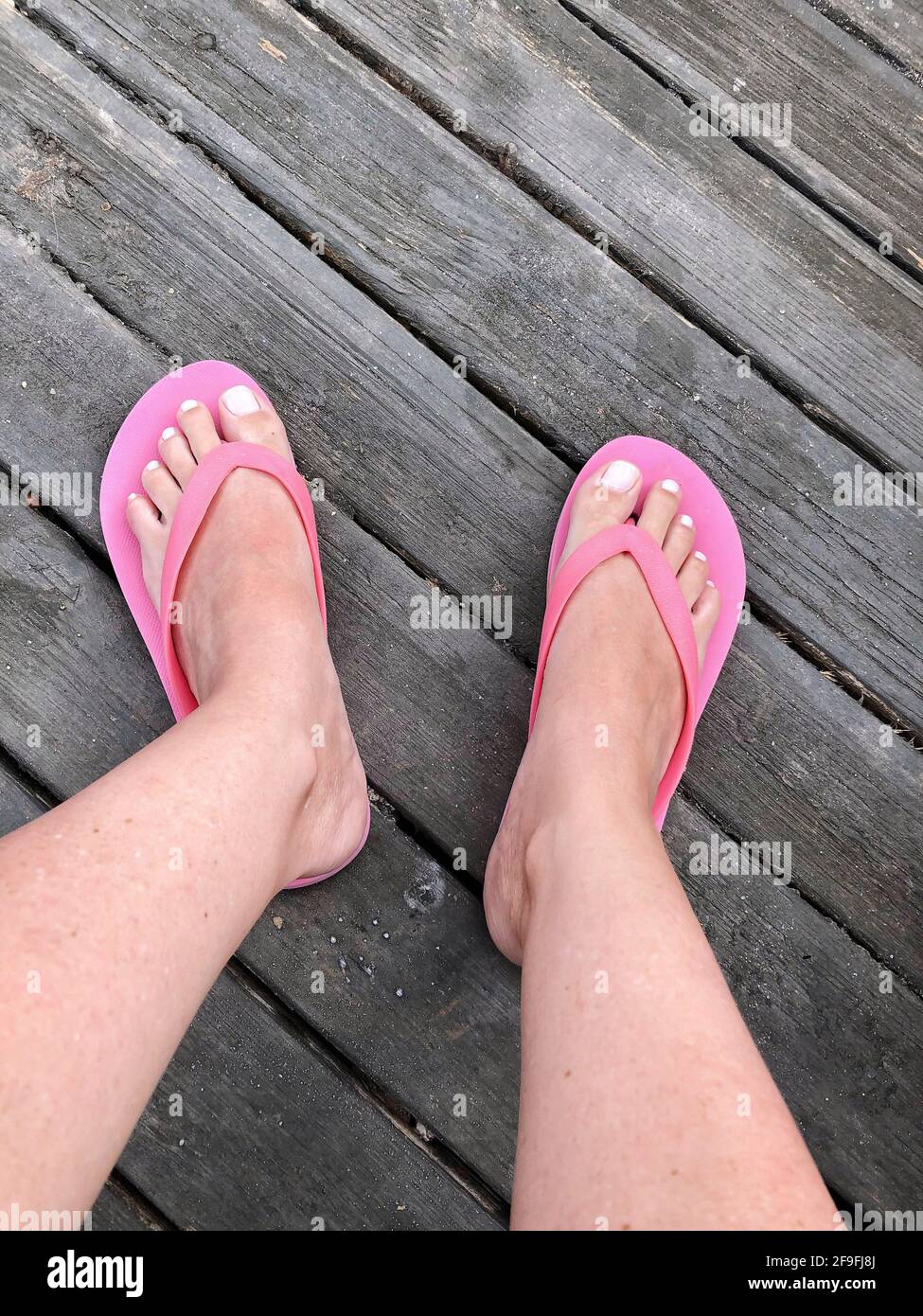 piedi di una donna che indossa infradito rosa Foto stock - Alamy