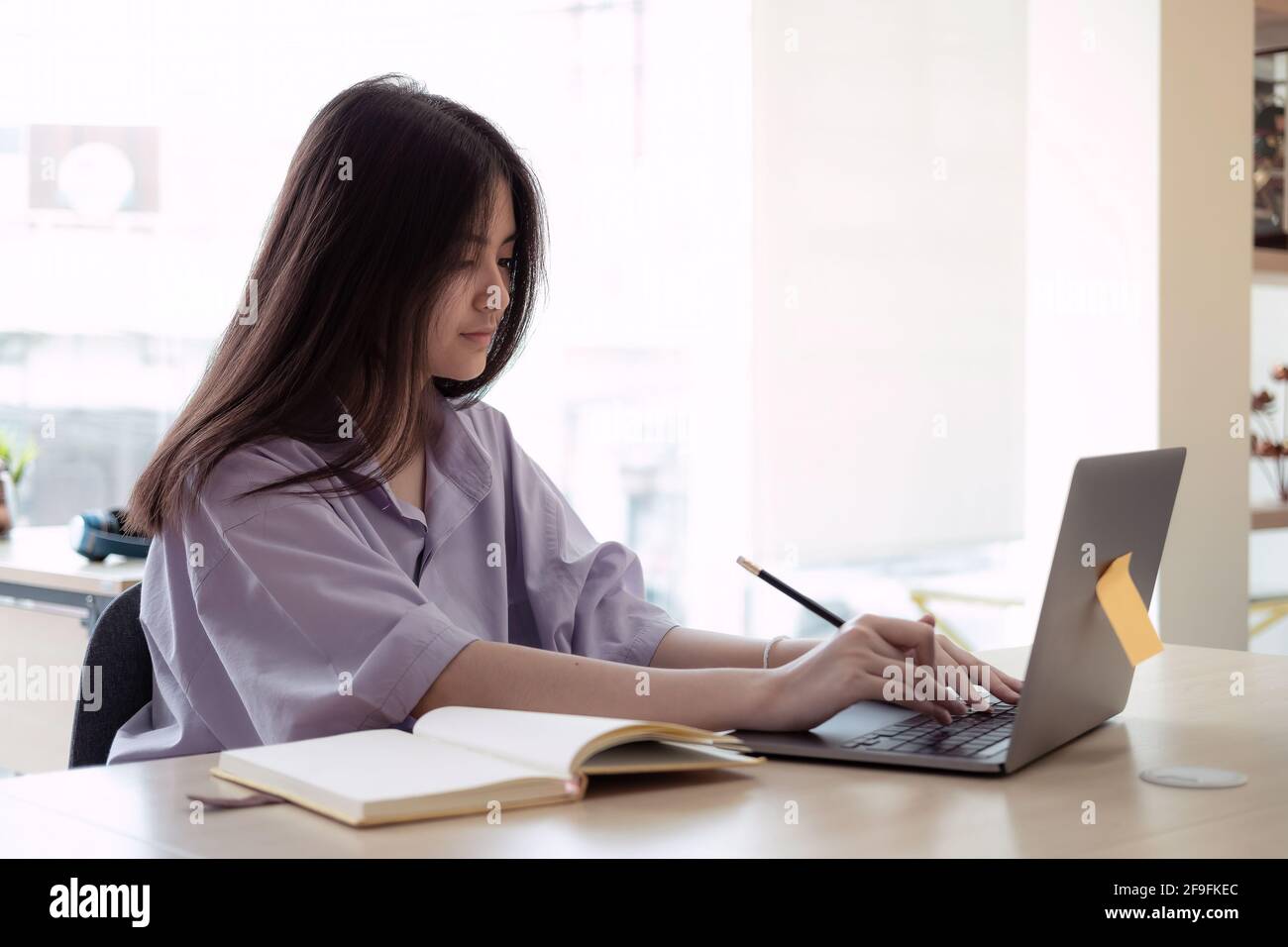 Formazione online. Asian ragazza lezione online utilizzando una videochiamata al computer per un insegnante virtuale a casa Foto Stock