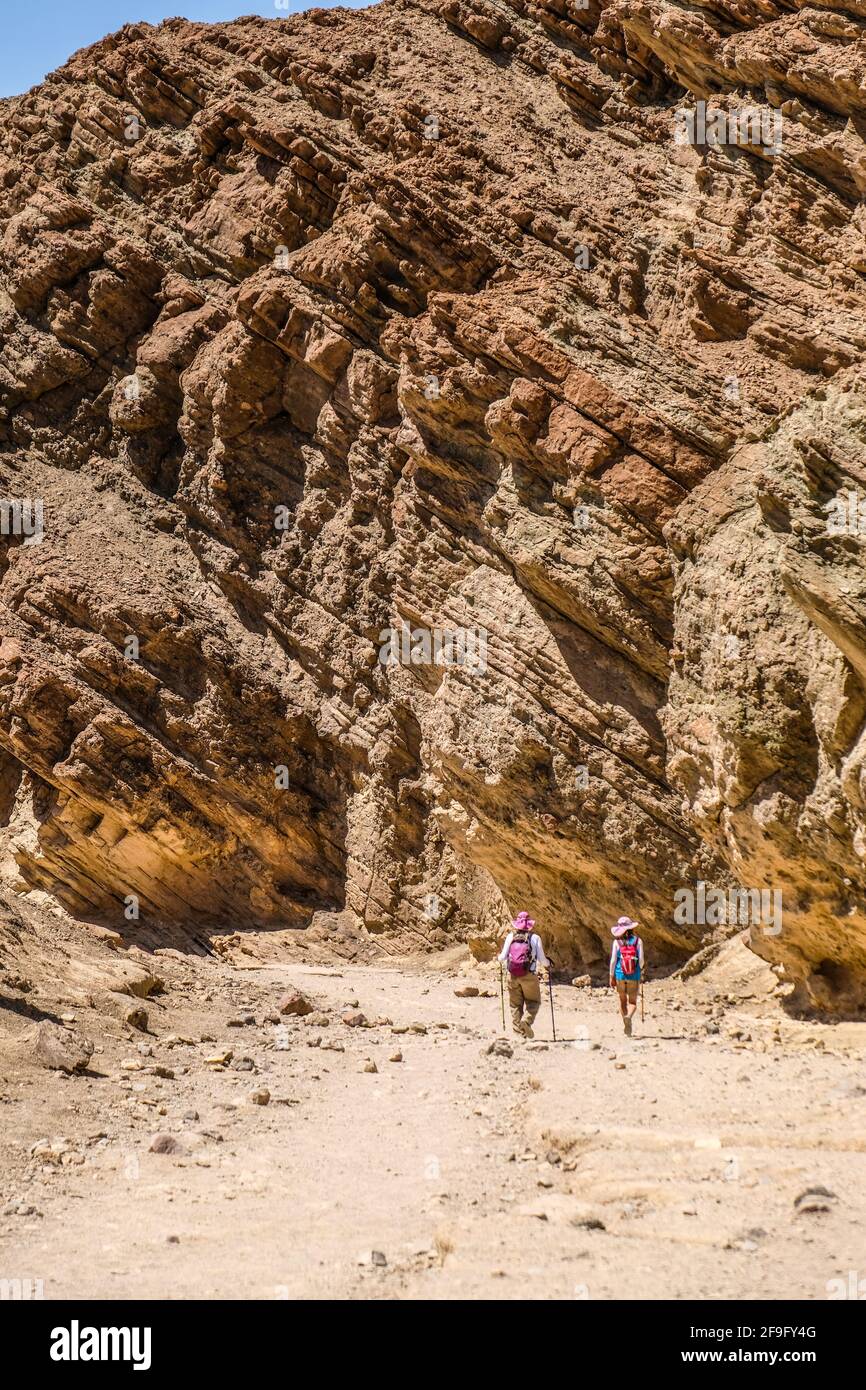 Due escursionisti femminili camminano attraverso il Golden Canyon nella Death Valley Parco nazionale Foto Stock