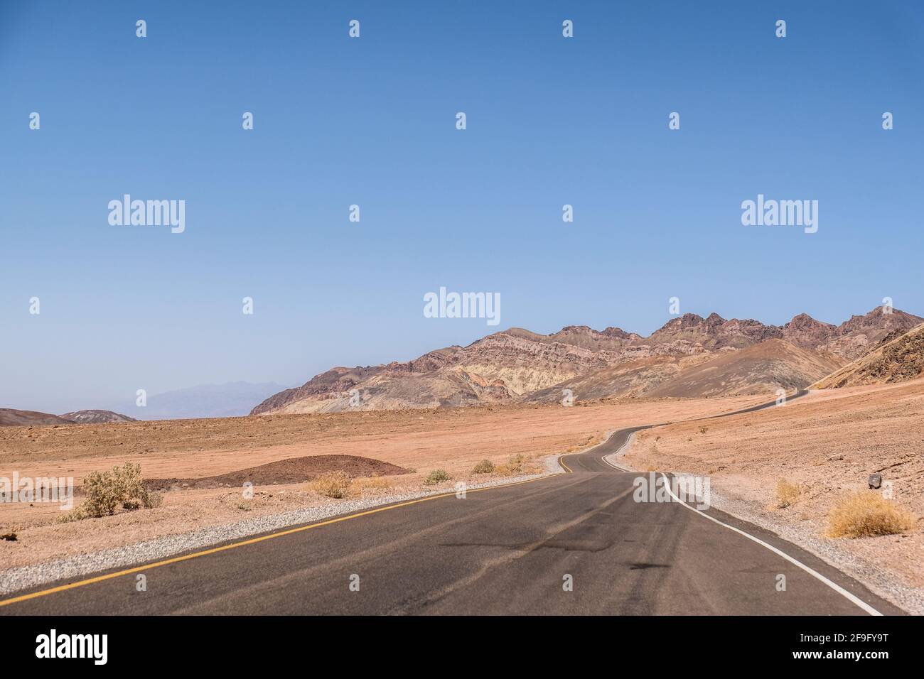 Empty Highway che percorri l'orizzonte nella Death Valley National Parcheggio Foto Stock