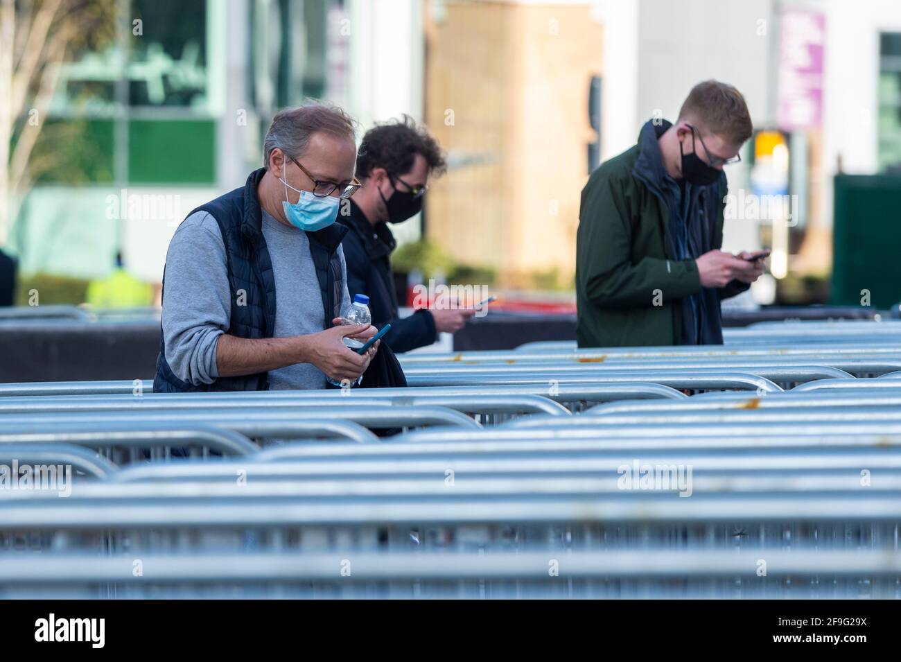 Londra, Regno Unito. 18 aprile 2021. Gli spettatori preparano prove di Covid-test da controllare da parte delle guardie di sicurezza fuori dallo stadio di Wembley prima della partita semifinale della fa Cup tra Leicester City e Southampton. 4,000 residenti locali sono stati invitati a partecipare alla partita, il maggior numero di spettatori che hanno partecipato a una partita in uno stadio del Regno Unito per oltre un anno. I test di Covid-19 verranno eseguiti prima e dopo la partita e i dati raccolti verranno utilizzati per pianificare in che modo tutti i tornei sportivi possono sfuggire al blocco. Credit: Stephen Chung / Alamy Live News Foto Stock