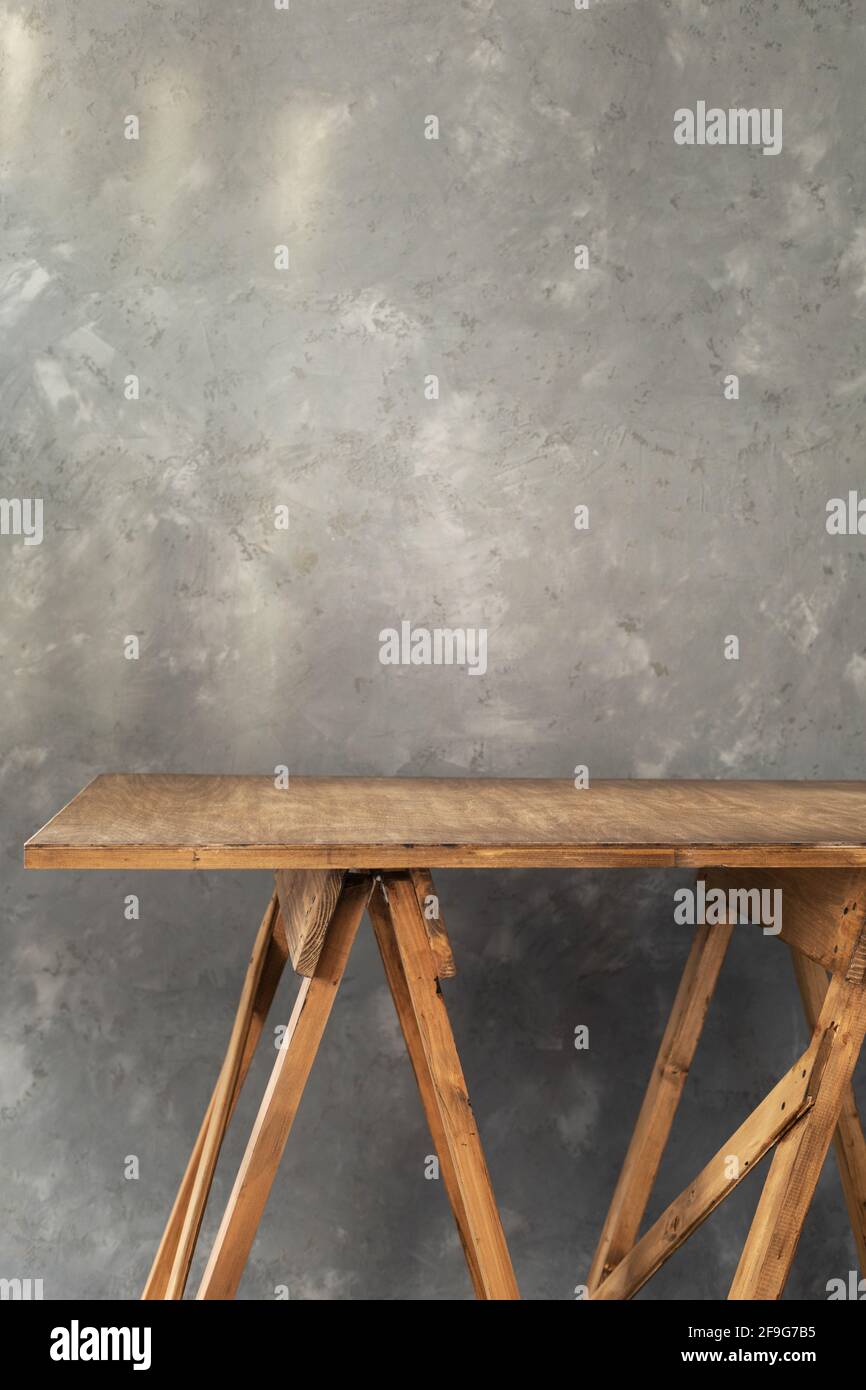 tavolo o piano di lavoro in legno vicino allo sfondo della parete in cemento, posto per le attrezzature Foto Stock