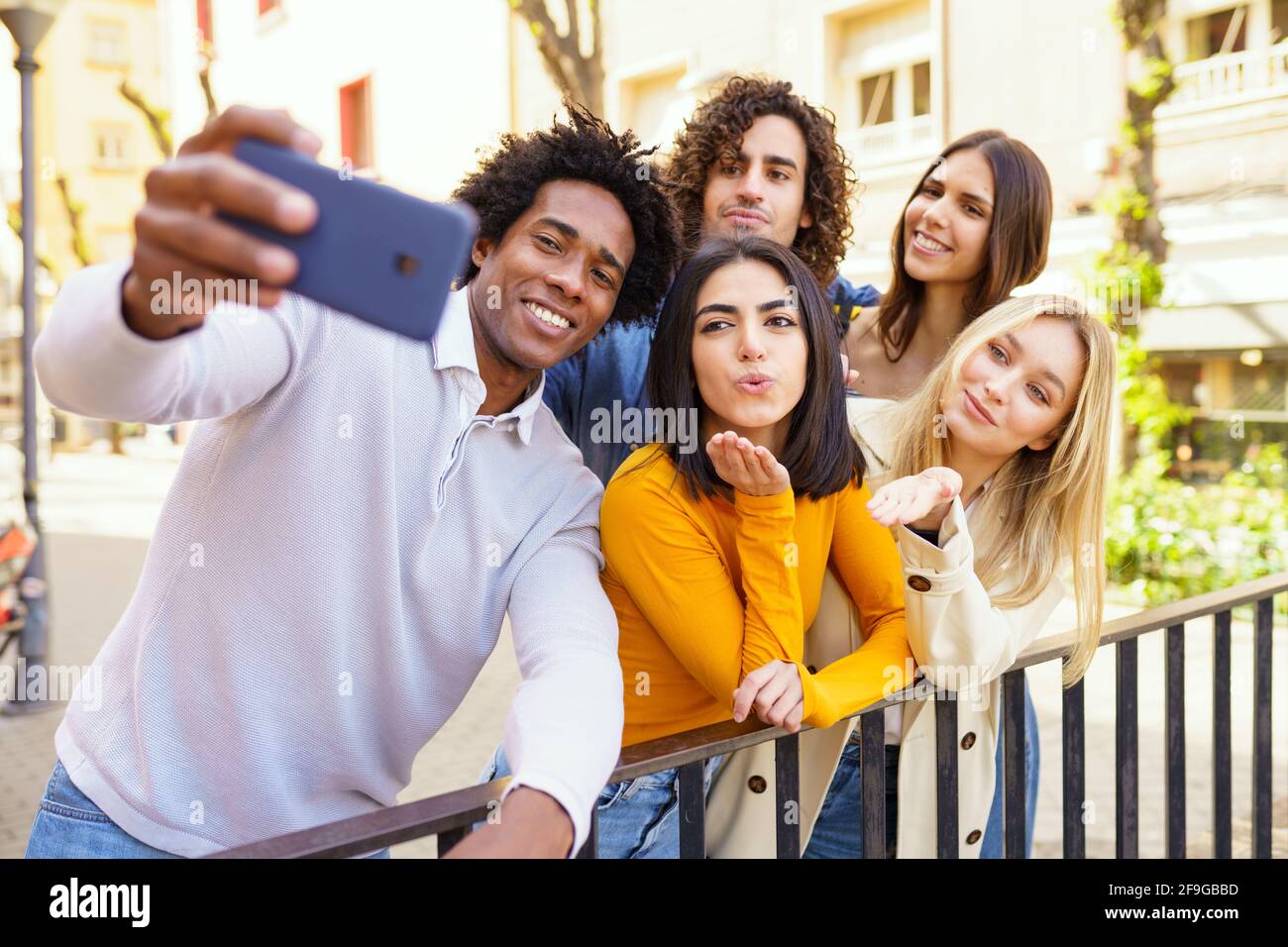Gruppo multietnico di amici che prendono selfie all'aperto con uno smartphone. Foto Stock