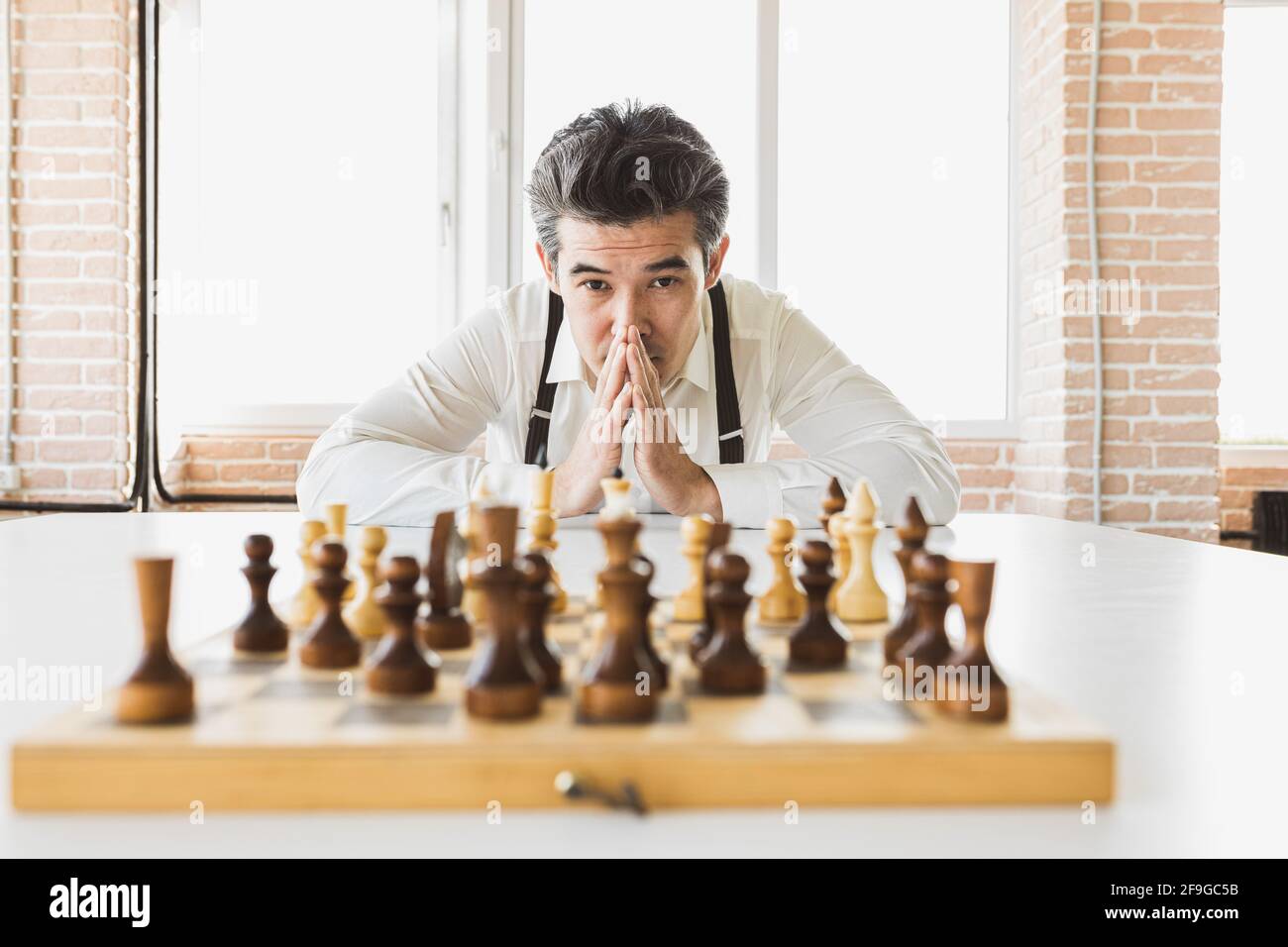 strategia di pianificazione con figure di scacchi su un vecchio tavolo di legno. Uomo d'affari che tiene e getta scacchi a . Obiettivi di installazione e target per le aziende Foto Stock