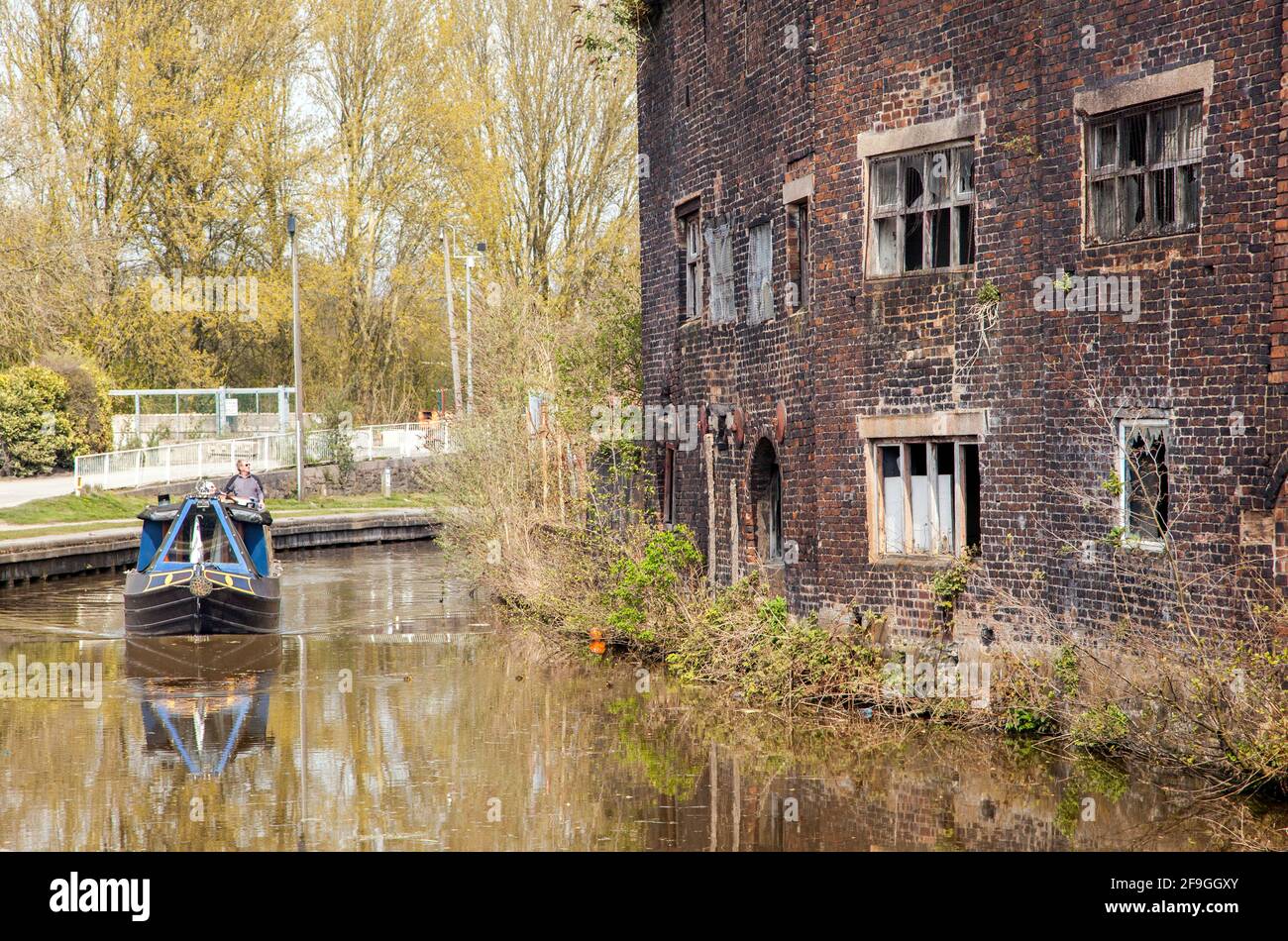 Canale narrowboat sul canale Trent e Mersey passando il Vecchio derelict Kensigton & Price lavori di ceramica e magazzino in Longport Stoke on Trent Foto Stock