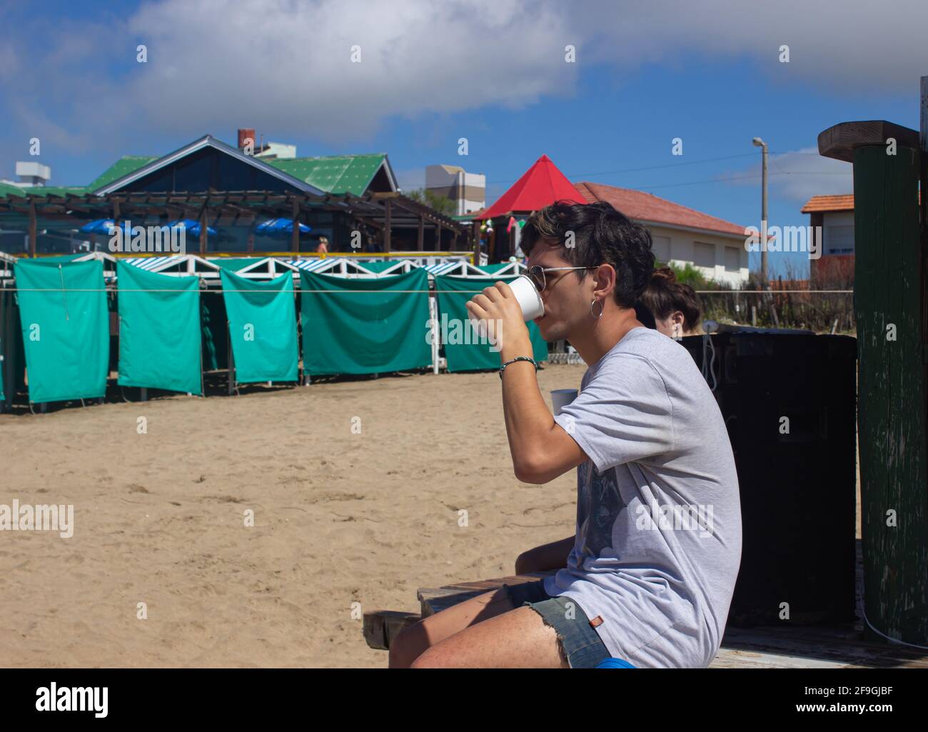 Giovane con bicchieri in spiaggia. Foto Stock