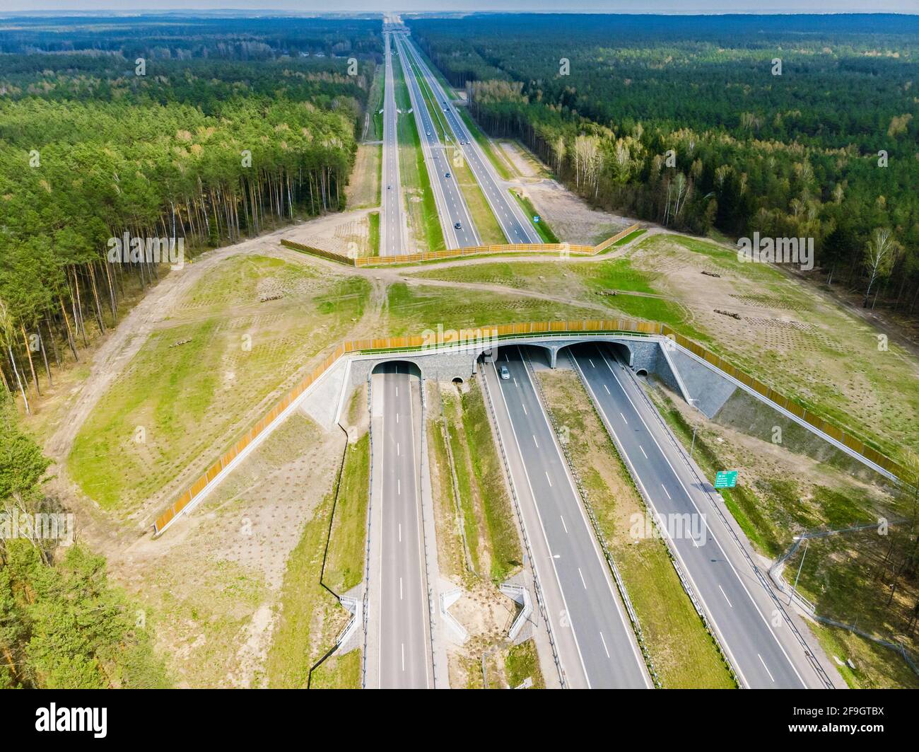 Expressway con attraversamento dell'ecodotto - ponte su un'autostrada che consente alla fauna selvatica di attraversare la strada in modo sicuro, vista aerea dall'alto verso il basso Foto Stock