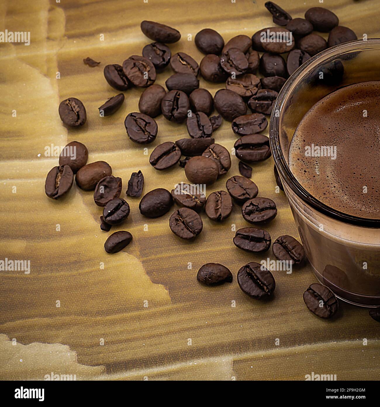 tazza di caffè con chicchi di caffè su sfondo di legno colorato Foto Stock