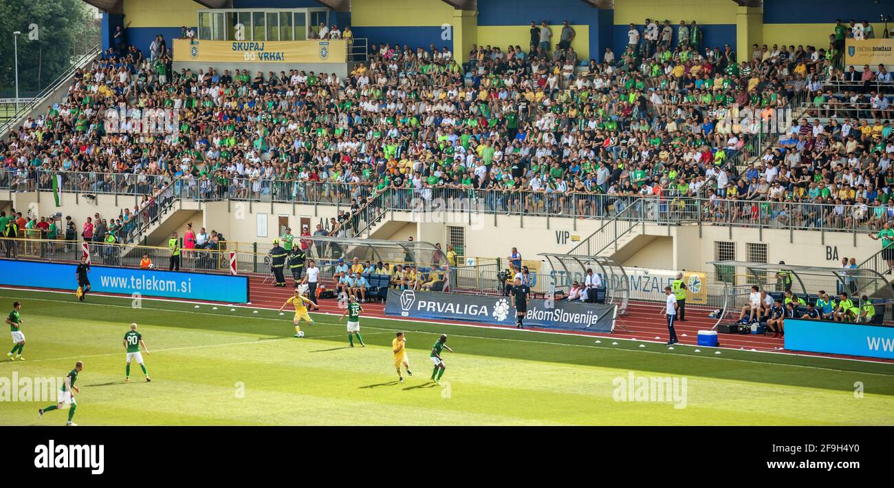 DOMZALE, SLOVENIA - 22 giugno 2019: Gli spettatori si siedono sulla tribuna e guardano la partita di calcio Foto Stock