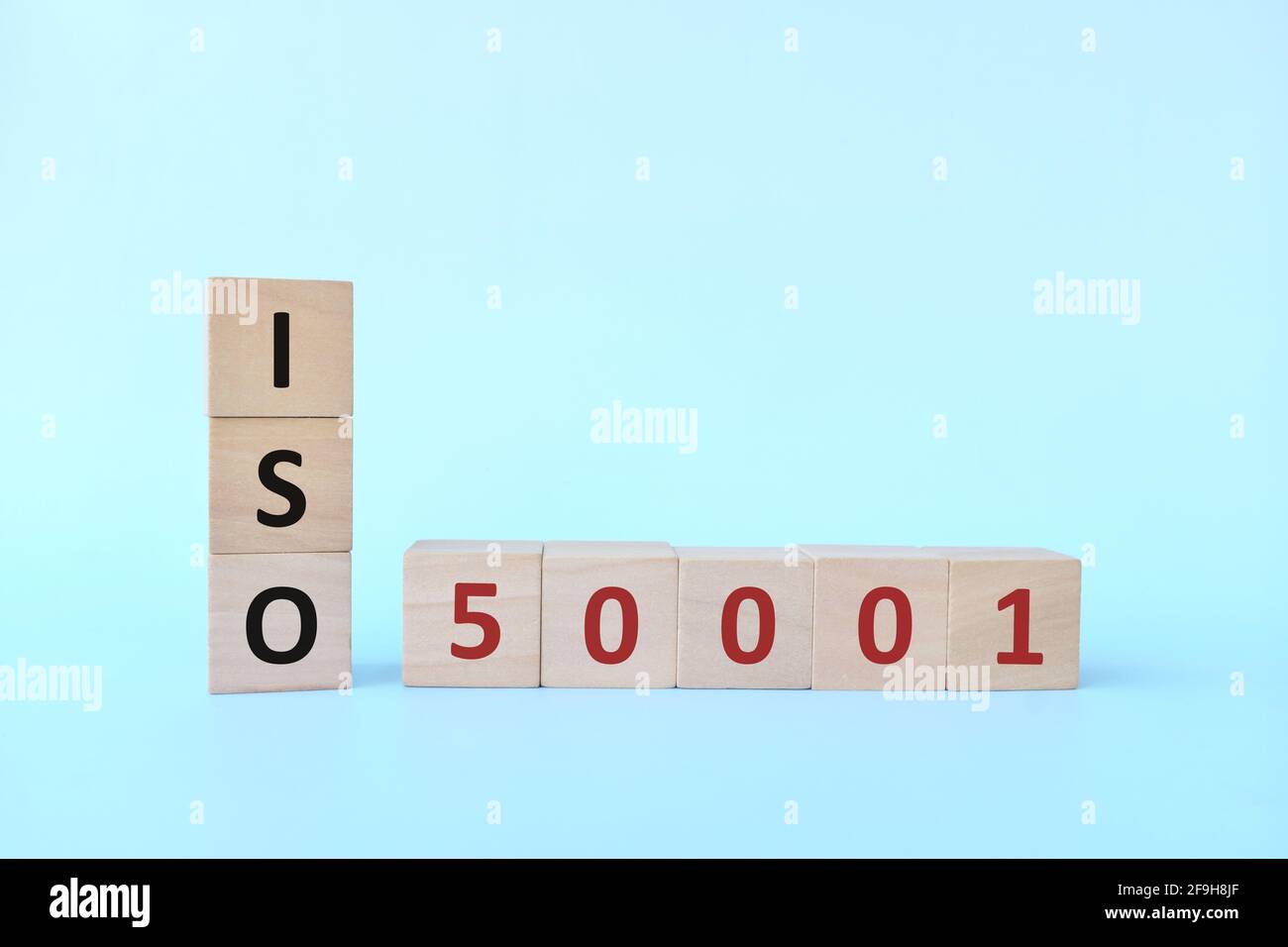 ISO 50001 o Energy Management Systems Concept su blocchi di legno su sfondo blu. Foto Stock
