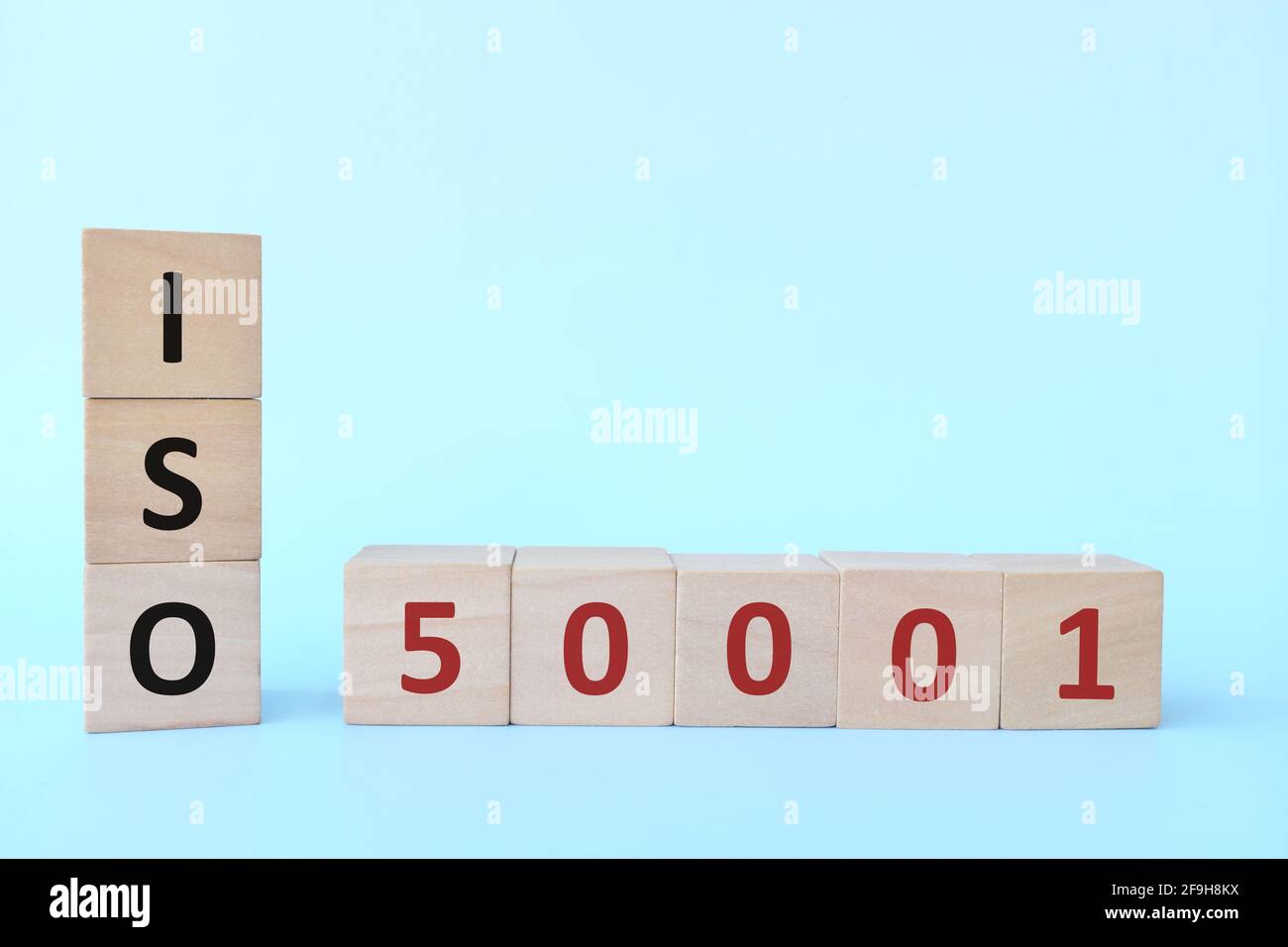 ISO 50001 o Energy Management Systems Concept su blocchi di legno su sfondo blu. Foto Stock