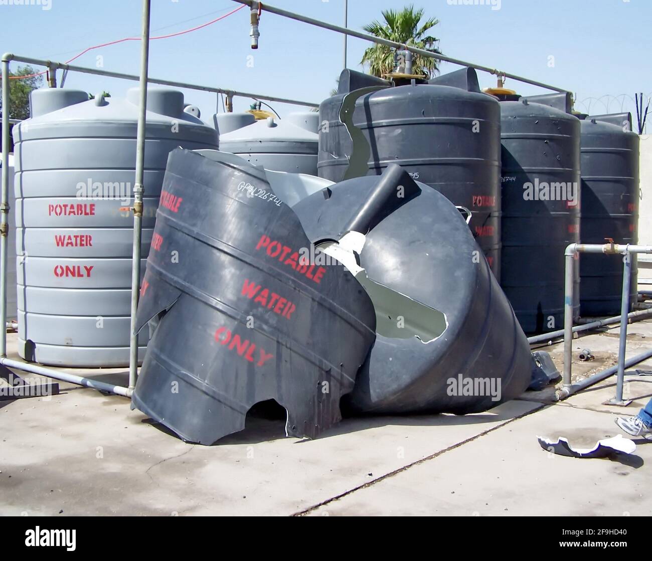 Serbatoi d'acqua in plastica distrutti da un'esplosione presso una base operativa di Forward a Baghdad, Iraq Foto Stock