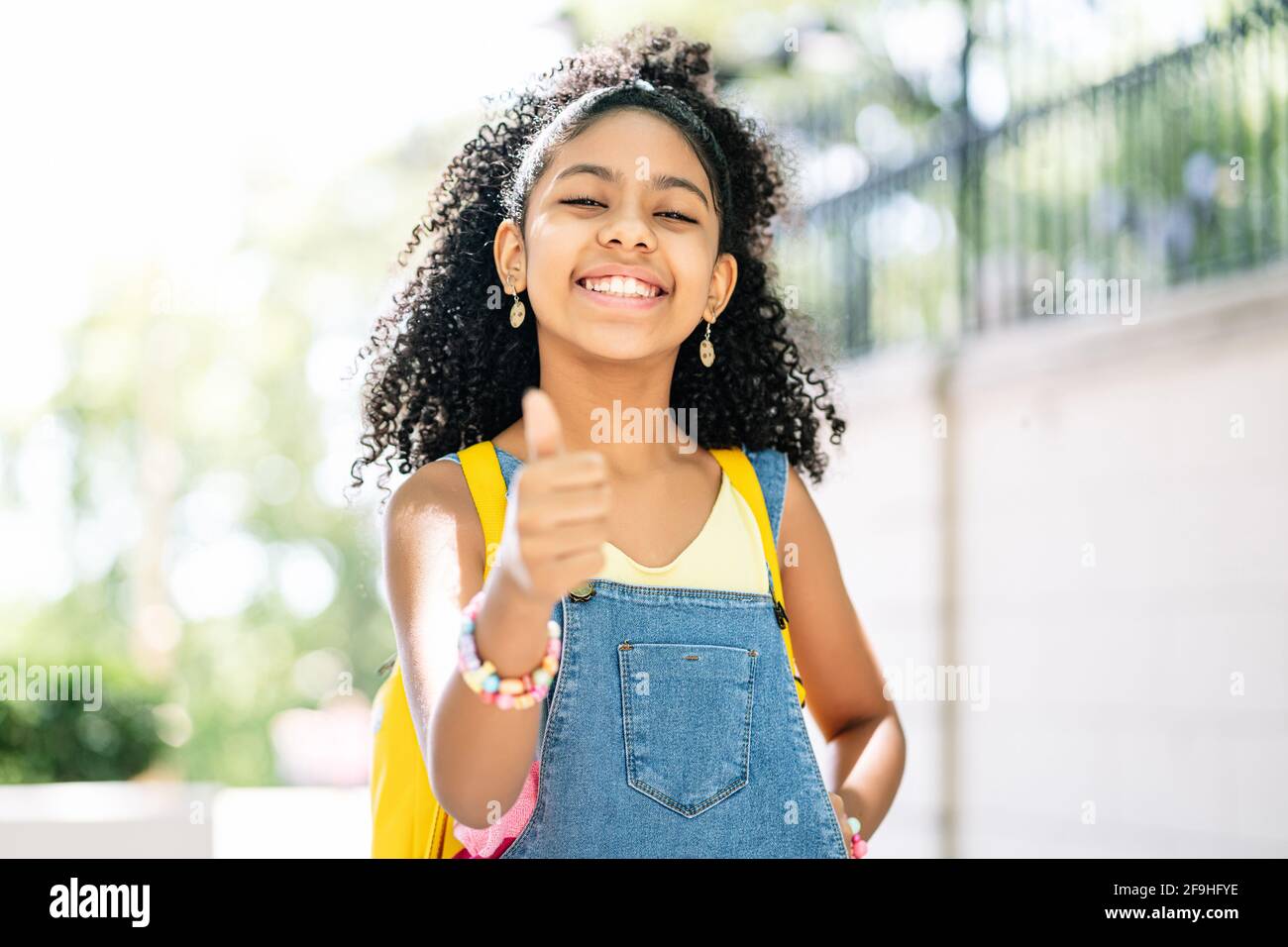 La bambina sorride e mostra il pollice in su. Foto Stock