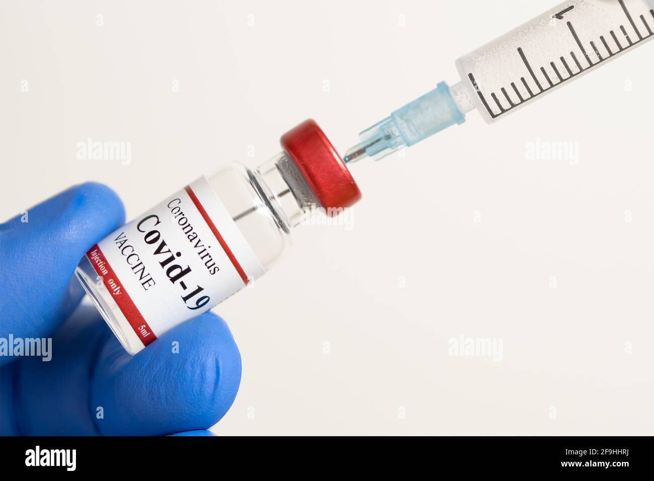 Medico che detiene il vaccino di Coronavirus e siringa che usa per prevenire l'infezione da COVID-19. Foto Stock
