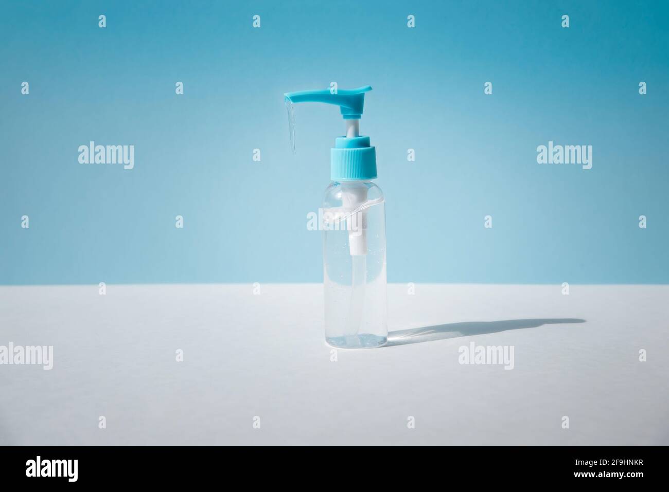 Dispenser con gel trasparente su fondo azzurro. Foto Stock