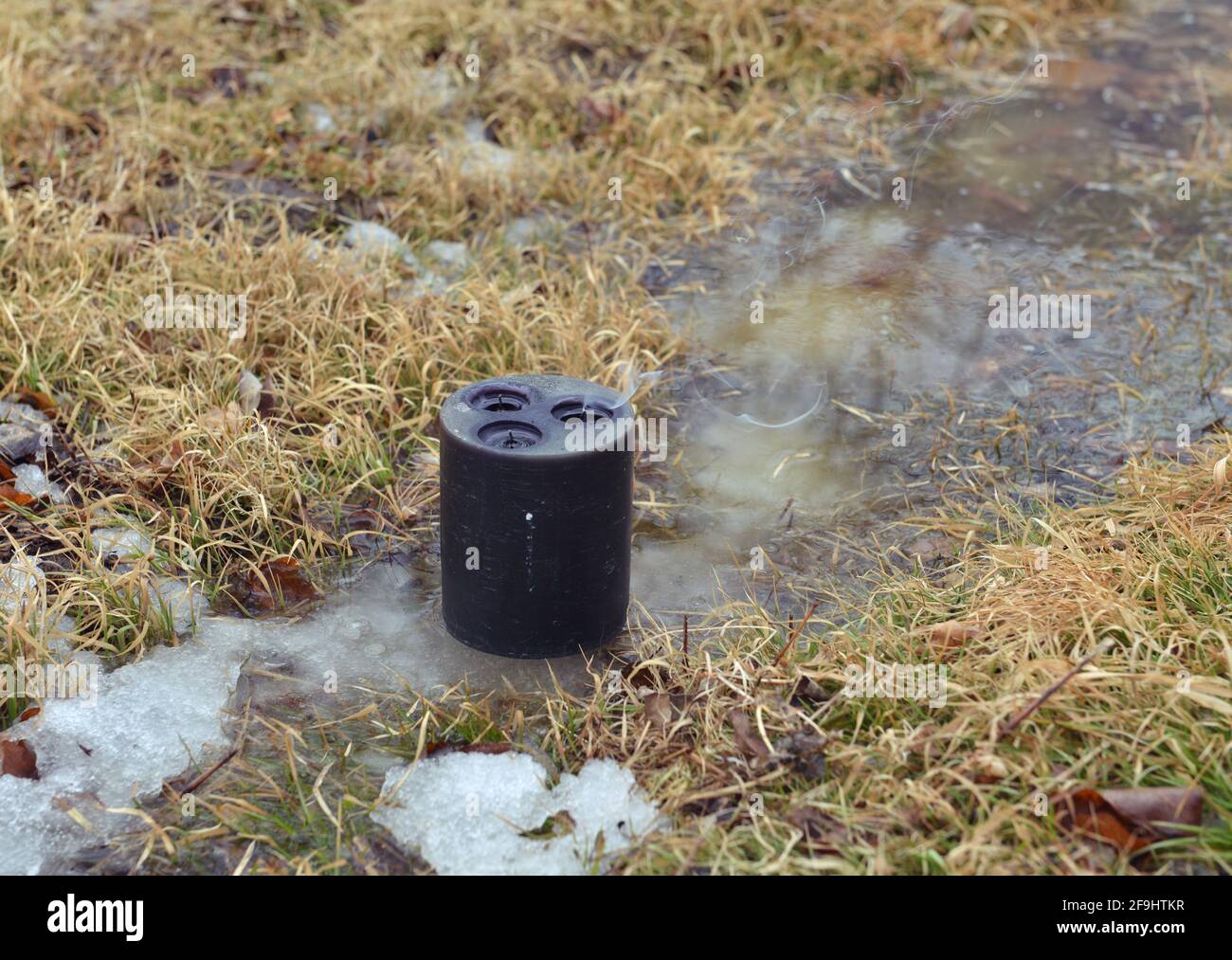Candela nera in acqua in primavera, rituale wiccan. Sfondo esoterico, gotico e occulto, Halloween mistico e wicca concetto all'aperto. Foto Stock