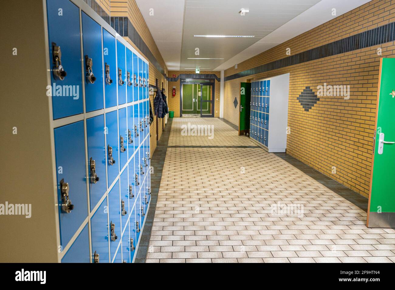 Corridoio vuoto e pulito con armadietti colorati per mobili e locale porta a scuola o università in germania. Foto Stock