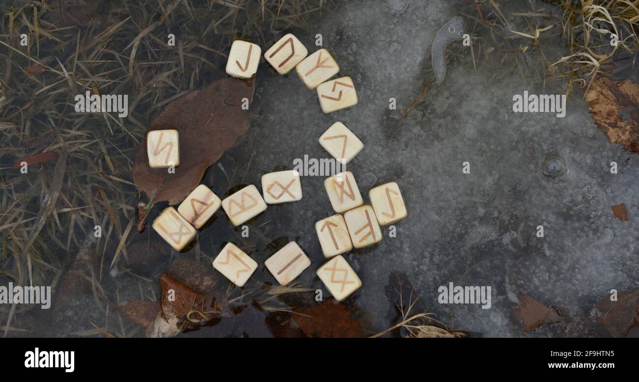 Rune di legno nell'acqua, rituale di wiccan con oggetti magici. Sfondo esoterico, gotico e occulto, Halloween mistico e wicca concetto all'aperto. Foto Stock