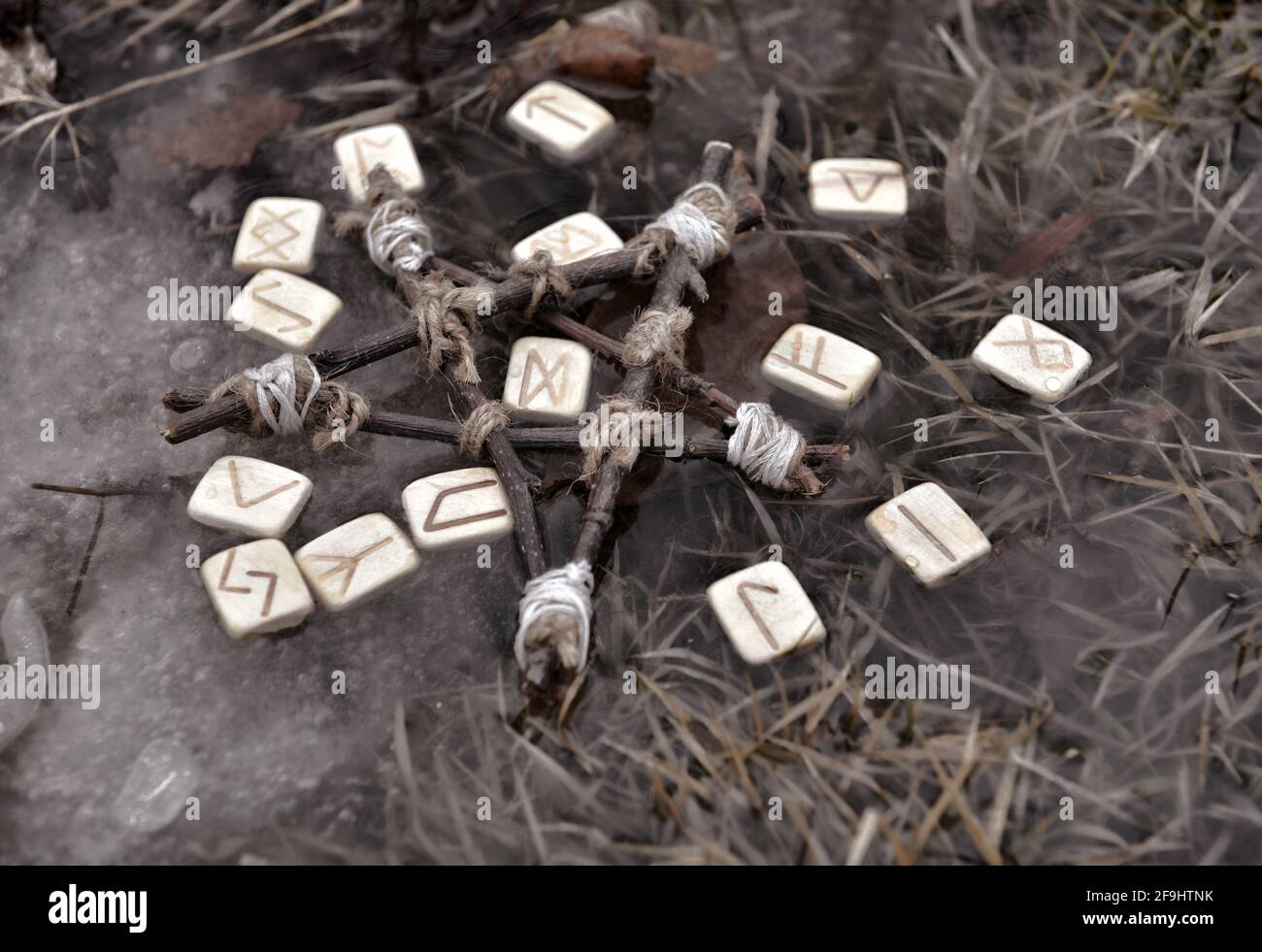 Ancora vita con pentagramma e rune di legno nell'acqua esterna. Sfondo esoterico, gotico e occulto, Halloween mistico e wicca concetto all'aperto. Foto Stock