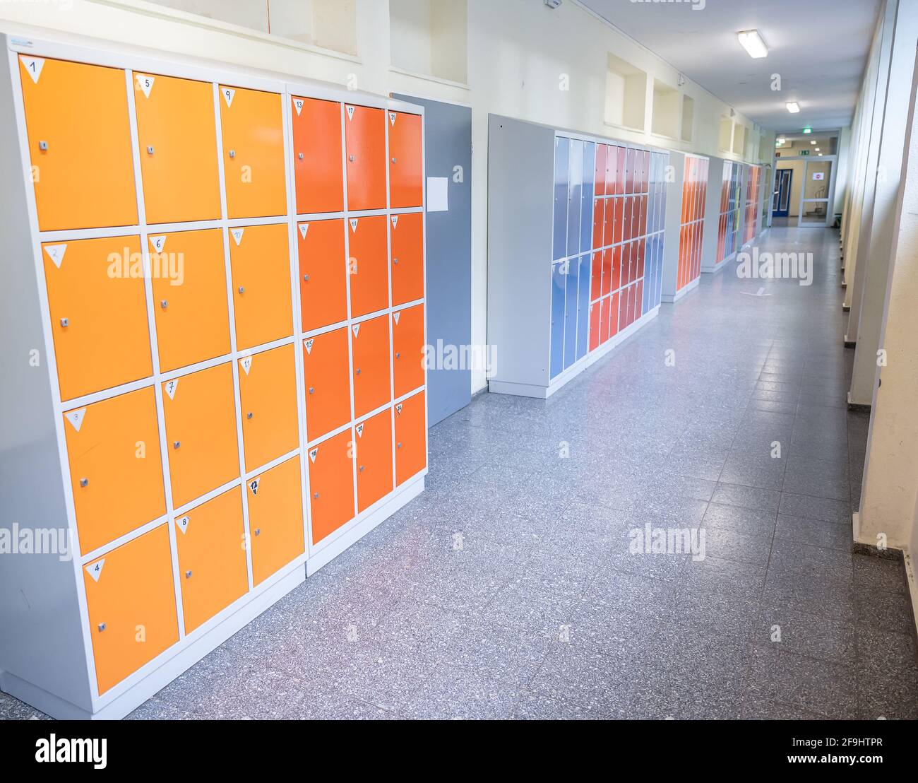 Corridoio vuoto e pulito con armadietti colorati per mobili e locale porta a scuola o università in germania. Foto Stock