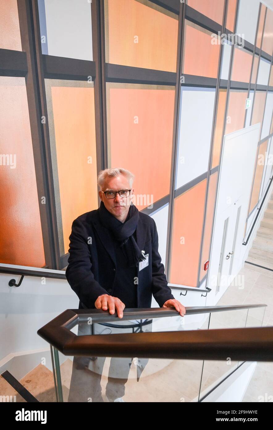 Berlino, Germania. 15 Aprile 2021. L'artista berlinese Tim Trantenroth si trova di fronte alle impressionanti strutture color bronzo che ha dipinto su una parete di una scala al Foro Humboldt, che ricorda la façade del Palazzo della Repubblica. Il Palast der Republik, da allora demolito, è stato aperto su questo sito il 23 aprile 1976. (A dpa 'un'esperienza in sé' - Palazzo della Repubblica aperto 45 anni fa') Credit: Jens Kalaene/dpa-Zentralbild/dpa/Alamy Live News Foto Stock
