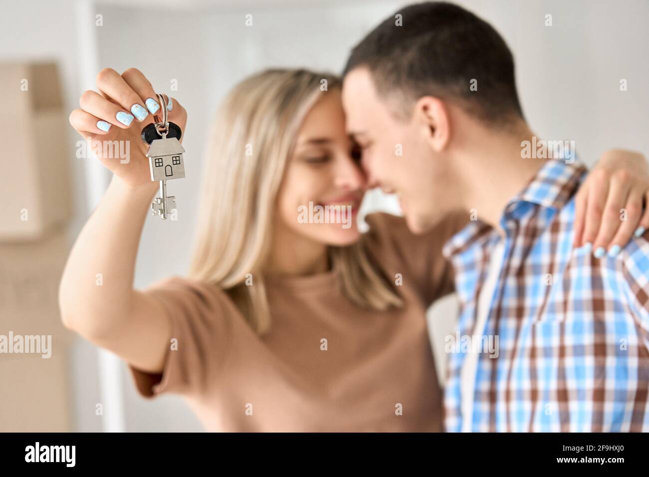 Felice giovane coppia primo tempo proprietari di casa tenendo le chiavi in casa nuova, primo piano. Foto Stock