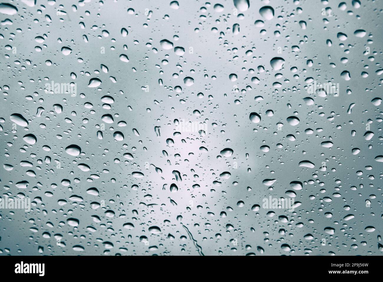 Gocce d'acqua sulla finestra. Pioggia sfondo. Sfondo sfocato con gocce di pioggia sul vetro, messa a fuoco morbida. Foto Stock