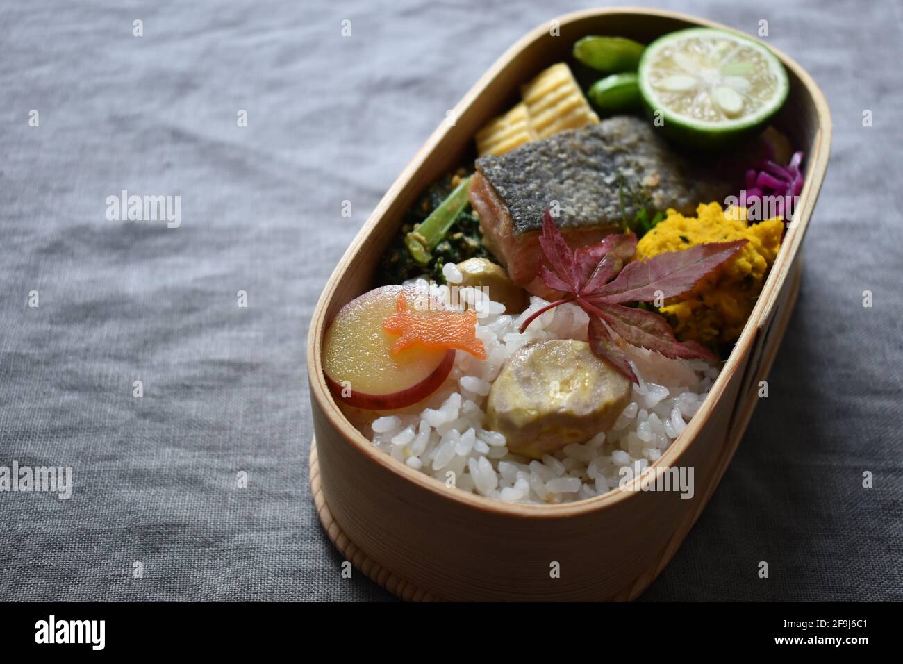 Wappa Bento, scatola per pranzo giapponese realizzata con piatto di legno rotondo, Meuniere di salmone Foto Stock