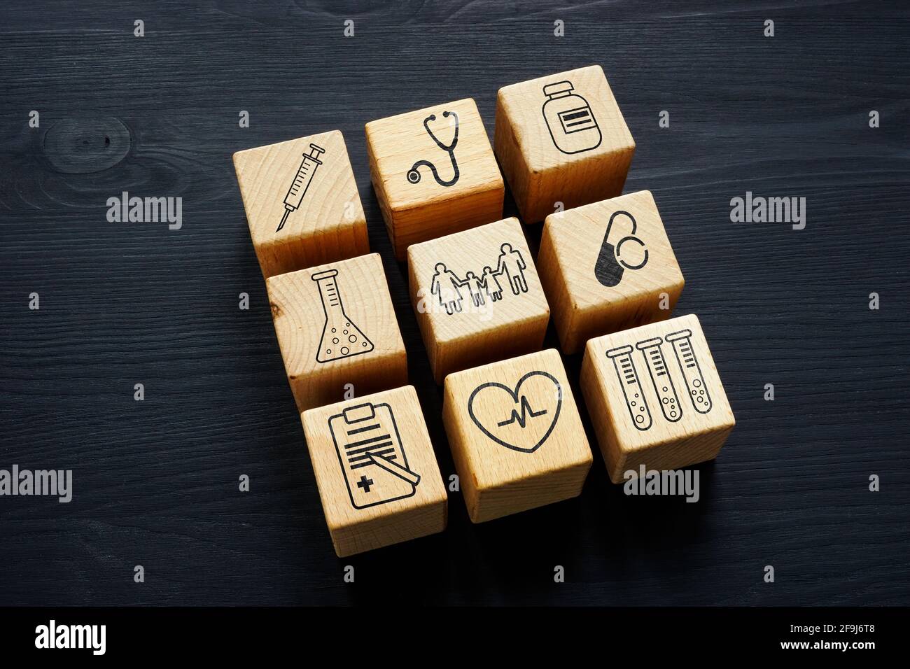 Medicina di famiglia e concetto di assicurazione sanitaria. Cubetti di legno sulla scrivania. Foto Stock