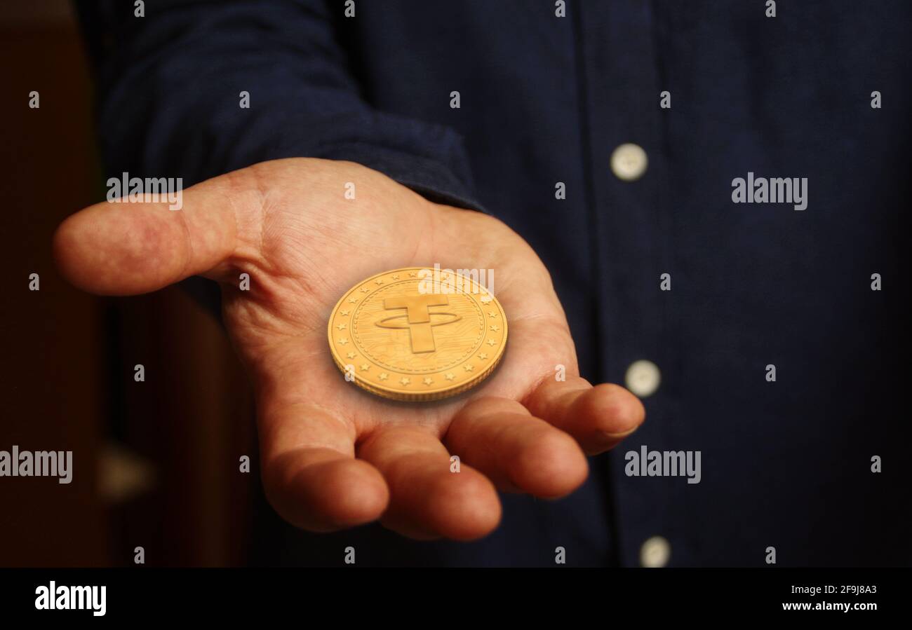 Teher simbolo criptovaluta moneta d'oro in mano concetto astratto. Foto Stock