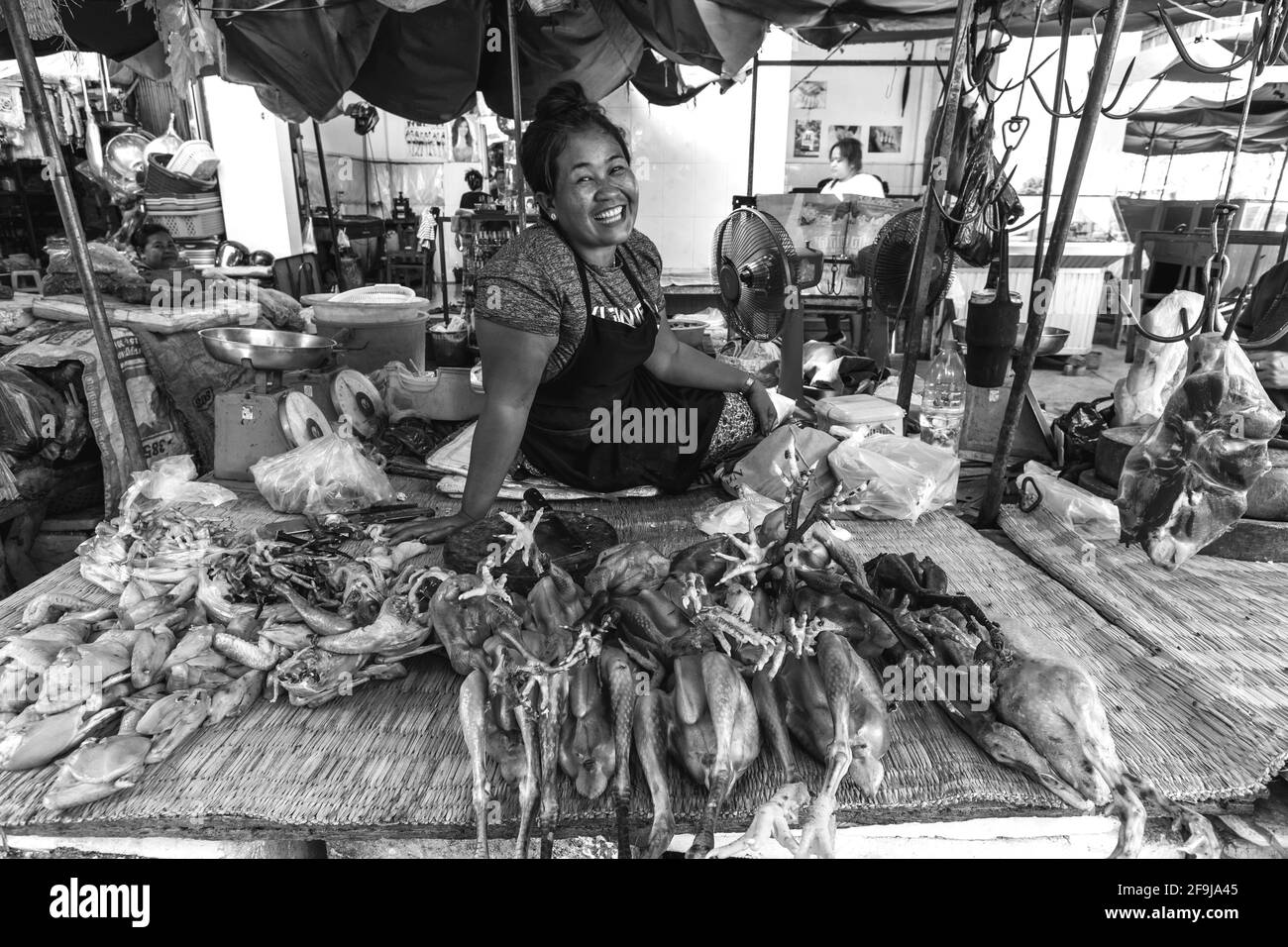 Un sorridente donna locale vende carni fresche a Phsar Chas Market (Mercato Vecchio) Phnom Penh Cambogia. Foto Stock