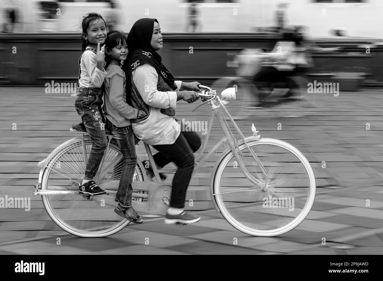 Una famiglia indonesiana in bicicletta a Taman Fatahillah Square, Jakarta, Indonesia. Foto Stock