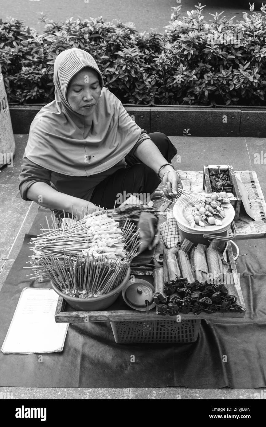 Una donna indonesiana che vende spuntini a Malioboro Street, Yogyakarta, Indonesia. Foto Stock