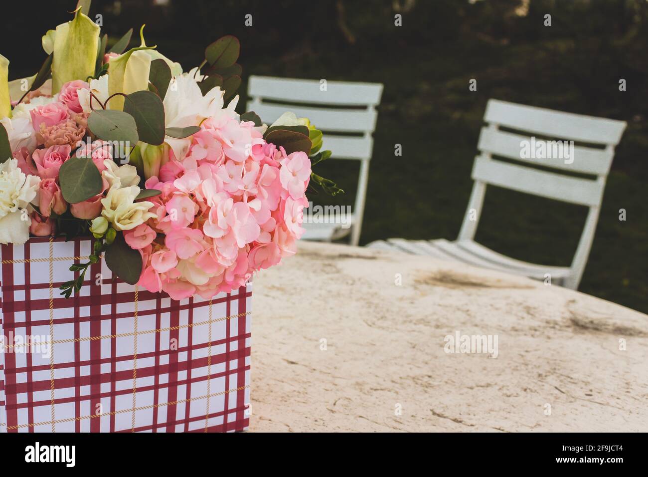 Fiori in confezione regalo all'esterno sul tavolo con spazio di testo Foto Stock