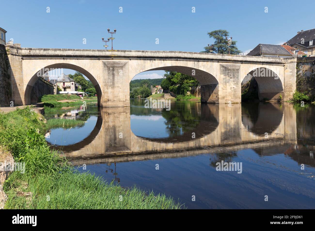 Un vecchio ponte di pietra sul fiume Vézère, e la sua riflessione, a Montignac, Dordogna, Francia Foto Stock