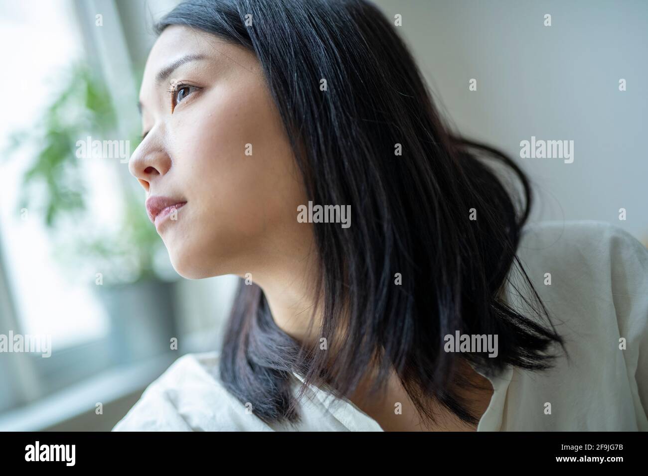 Guardare fuori dalla finestra Foto Stock