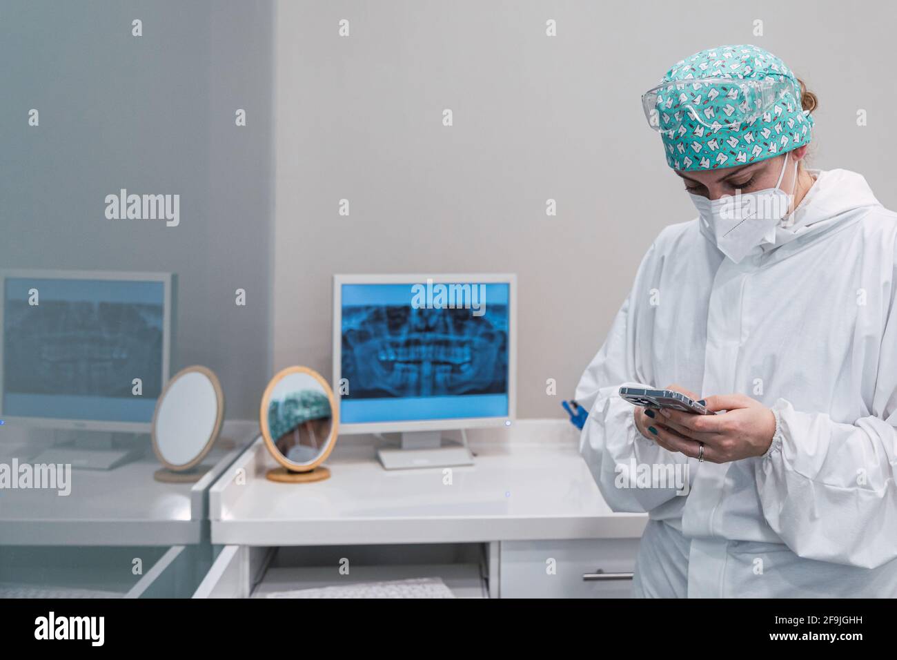 Donna dentista con uno smartphone in mano l'ufficio odontoiatrico Foto Stock