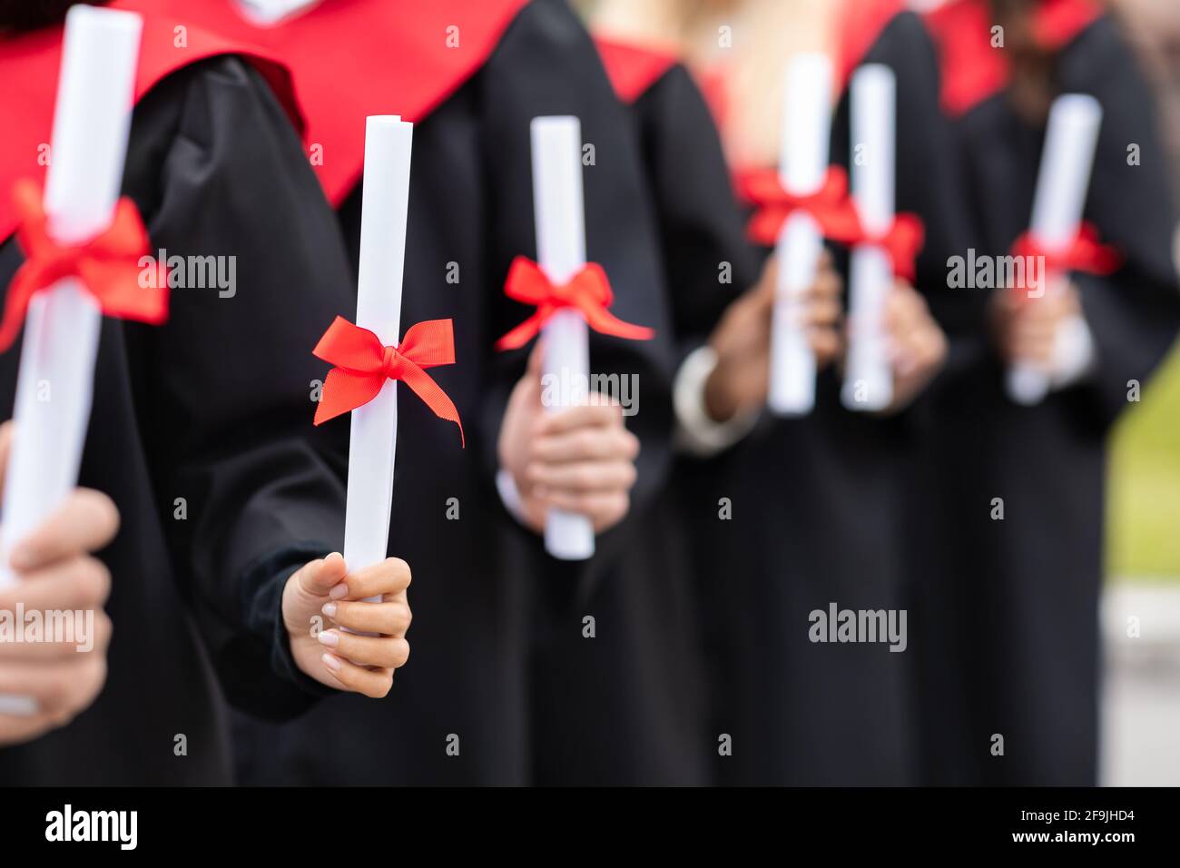 Gruppo multirazziale irriconoscibile di laureati in possesso di diplomi Foto Stock