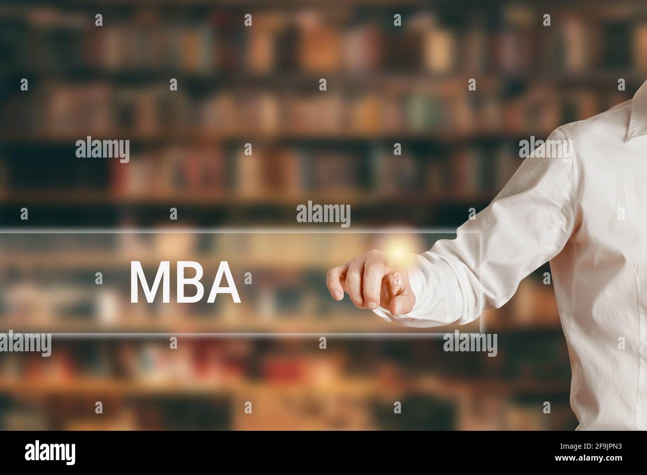 Mano maschile premendo la parola MBA su una barra di visualizzazione della  ricerca virtuale sullo sfondo della libreria. Master in formazione per  l'amministrazione aziendale Foto stock - Alamy