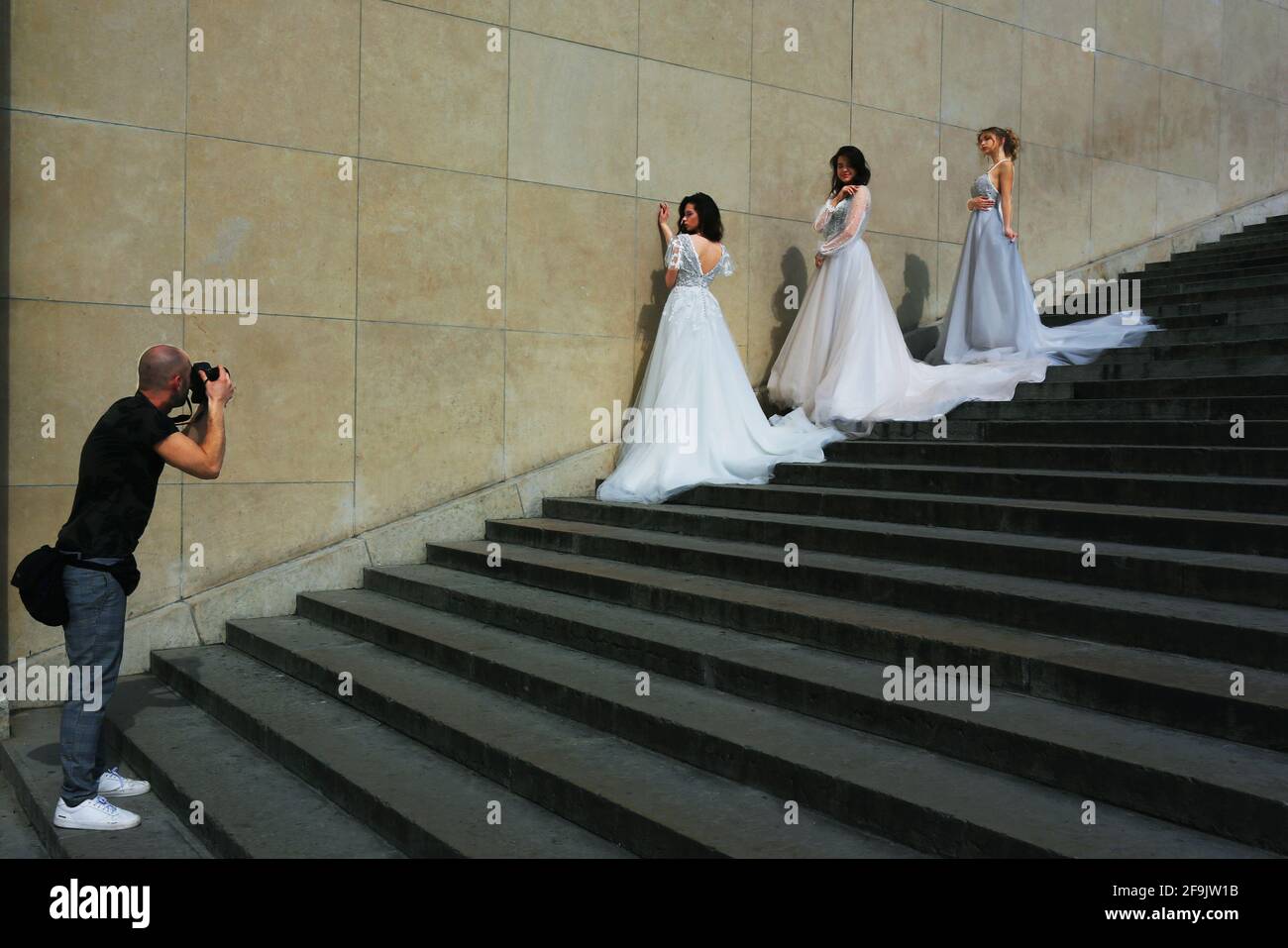 3 Modelle in Brautkleidern werden von einem Fotograf a Parigi abgelichtet Foto Stock