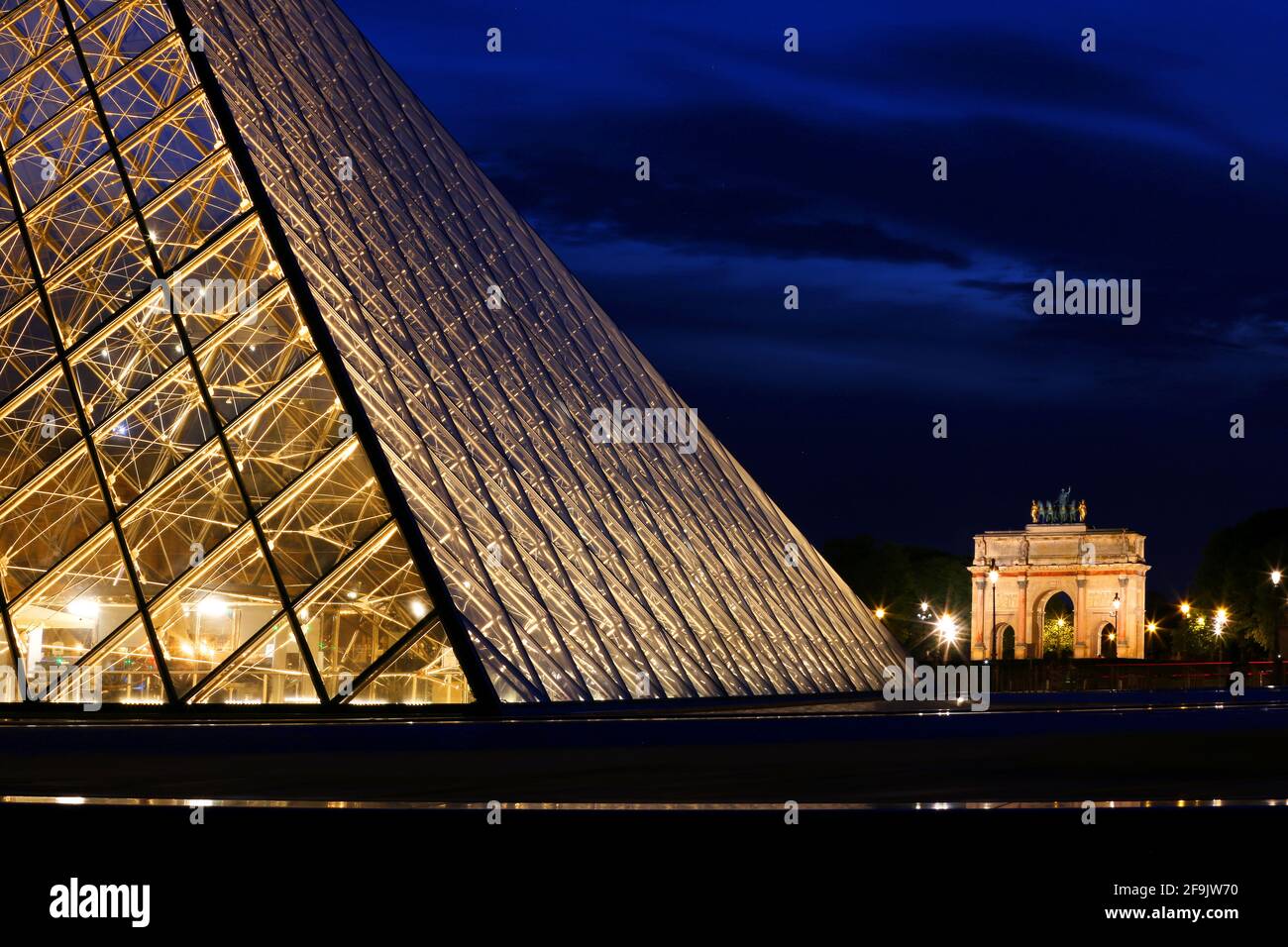 Parigi, Frankreich, die hell erleuchtete Glaspyramide des Pariser Louvre Museums strahlt a Parigi in der Nacht Foto Stock