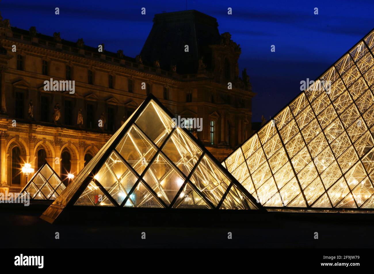 Parigi, Frankreich, die hell erleuchtete Glaspyramide des Pariser Louvre Museums strahlt a Parigi in der Nacht Foto Stock
