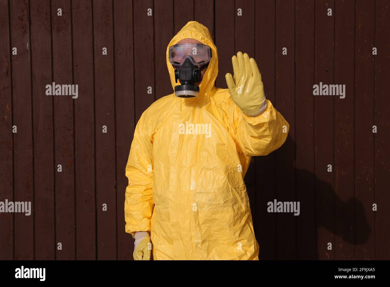 Mann im Schutzanzug hebt die hand - indumenti da lavoro e protettivi abbigliamento Foto Stock