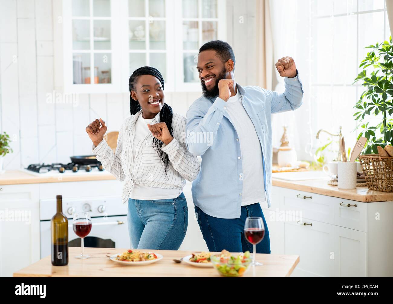 Data di residenza. Gioiosa coppia Nera Danza in cucina dopo un pranzo romantico Foto Stock