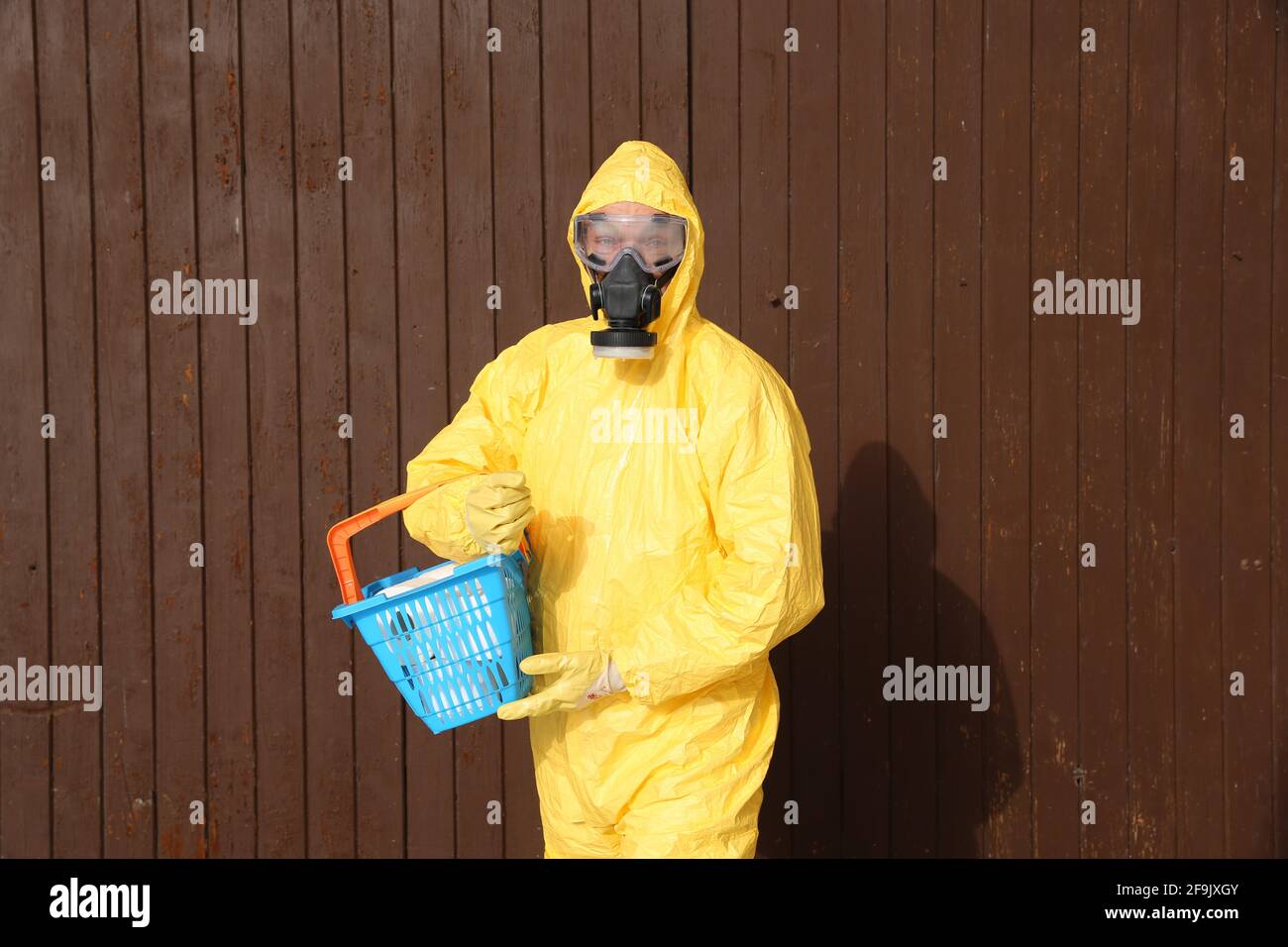 Mann im Schutzanzug mit Einkaufskorb - indumenti da lavoro e protettivi Foto Stock