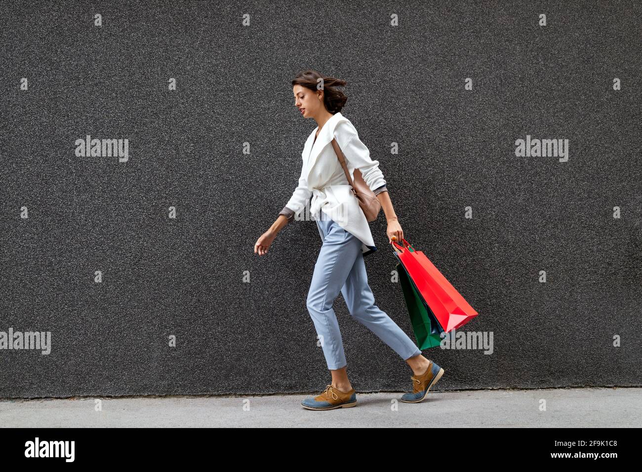 Ritratto di bella giovane donna sorridente con borse per lo shopping Foto Stock