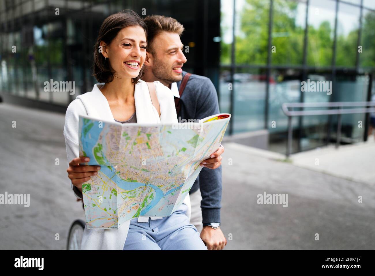 Felice sorridente donna e uomo in amore a piedi con mappa in città Foto Stock