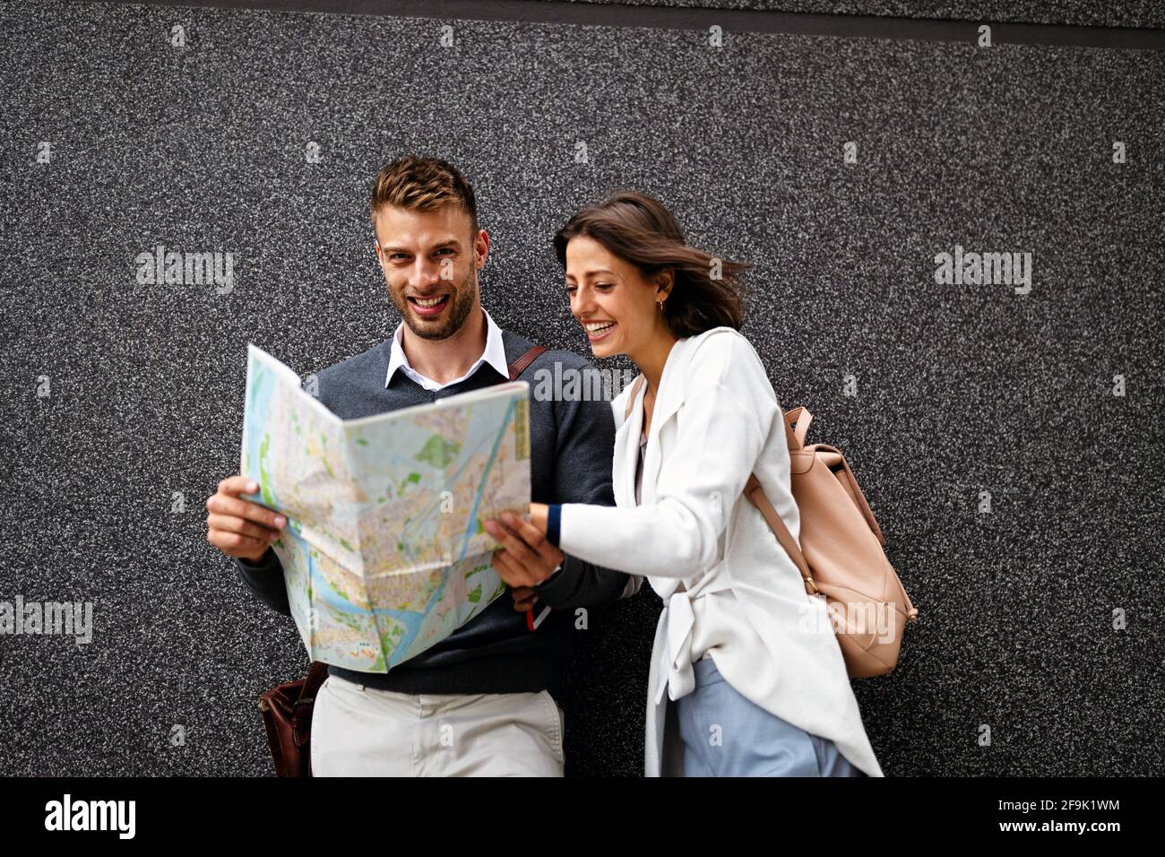 Felice sorridente donna e uomo in amore a piedi con mappa in città Foto Stock