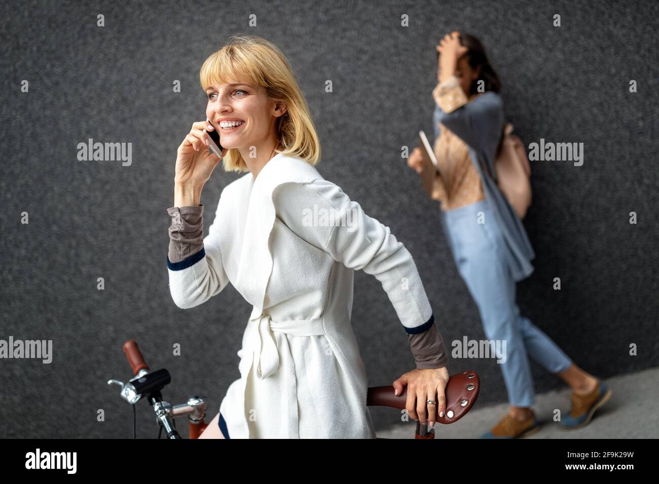 Bella giovane donna felice con smartphone nella strada della città Foto Stock
